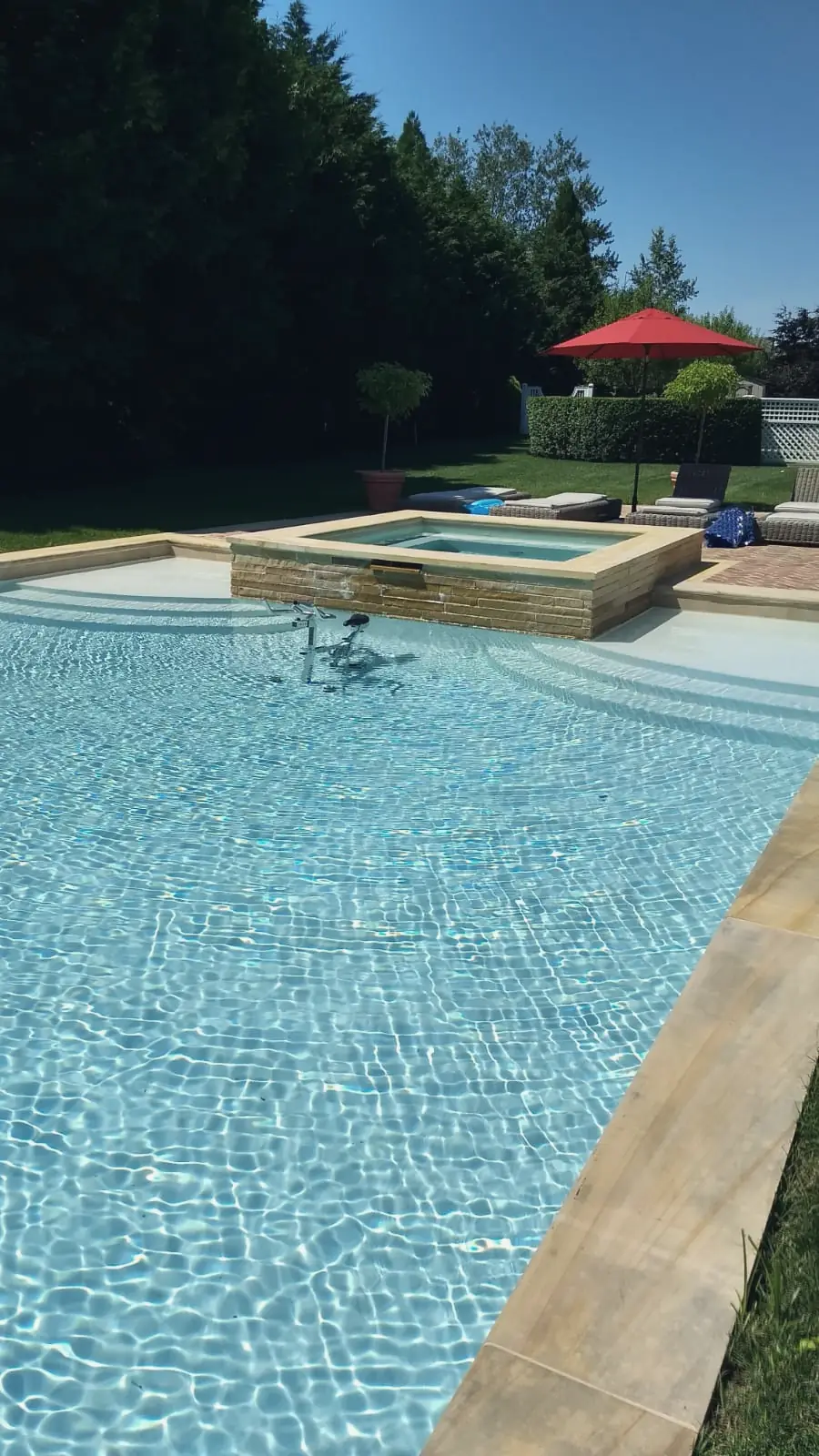 Clear pool with a sun shelf and raised spa